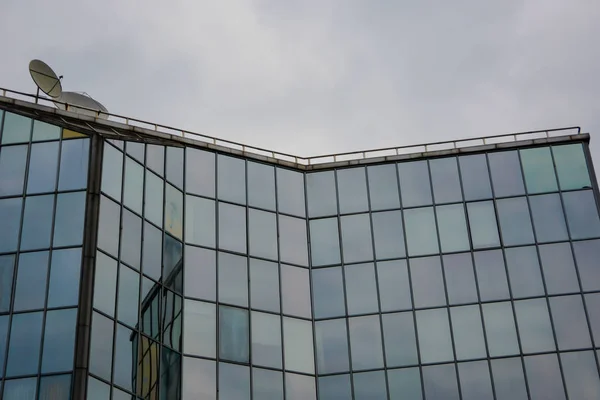 Futuristic Building. A modern architecture structure with a curved glass facade. Contemporary architectural fiction. Glazed aluminum structure. Lookup to the angle of the corner building.