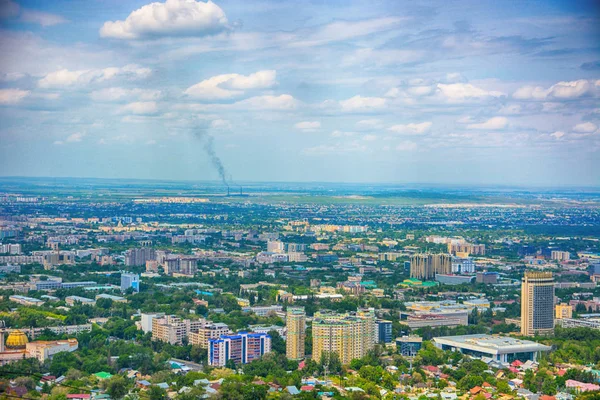 Panoramiczny widok na miasto Almaty, ze strefą przemysłową, górami i niebem z chmurami. Oglądane z kok tobe, Kazachstan. — Zdjęcie stockowe