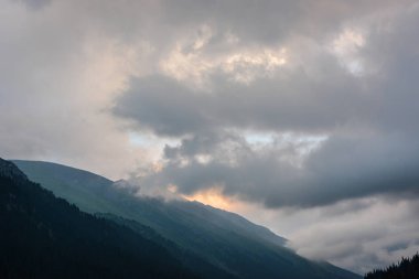 Akşamları bulutlar ve gri gökyüzü ile güzel manzara dağlar. Huzurlu açık hava sahnesi.