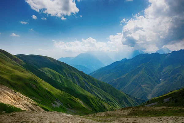 Idylický letní krajina s turistické stezky v horách s krásnými svěží zelené horské pastviny. — Stock fotografie