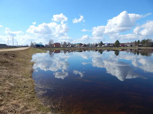     Beyaz bulutlar gölün yüzeyine yansıyor.