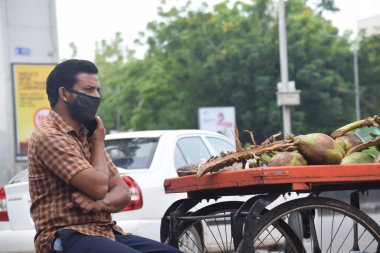 Hyderabad, Telangana, Hindistan. Temmuz-06-2020: Bir adam yolda hindistan cevizi satıyor, maske takıyor, korona salgını, sokak pazarı