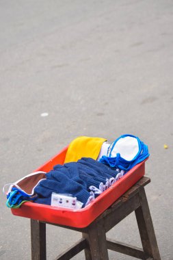 Korona virüsüne karşı koruyucu maske, Corona maskeleri yolda satmaya hazırlar, salgın hastalık konsepti, yol kenarında bir sürü maske ve eldiven var.