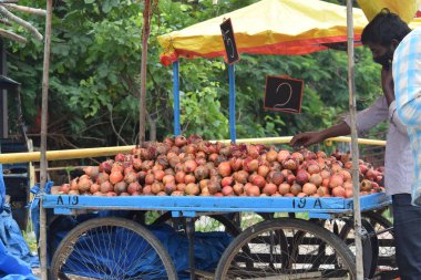 Hyderabad, Telangana, Hindistan. Temmuz-22-2020: Meyveler yol kenarında, meyve tüccarı yol kenarında meyve satarken koronavirüsten korunmak için maske takıyor, korona salgını zamanı, insanlar meyve alırken koruyucu maskeler takıyor