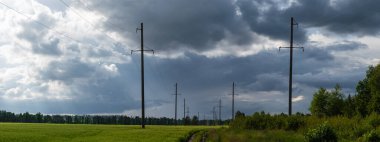 Fırtınalı gökyüzü. Sahada mısır var. Ormanda yeşil alanlar.