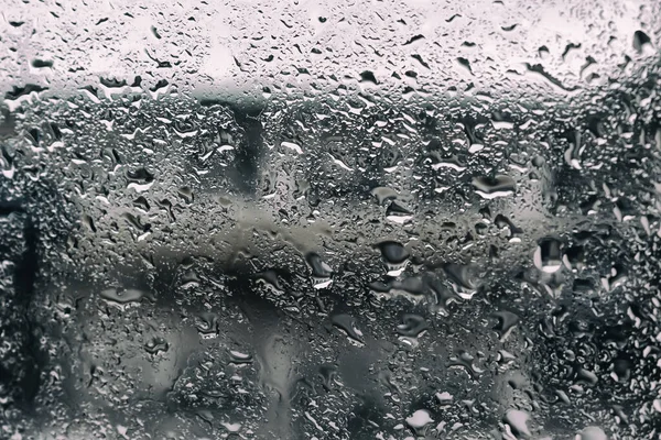 雨滴落在黑暗的背景上 雨滴落在玻璃杯上 湿蒙蒙的玻璃杯上的雨滴 蓝色的背 图库图片