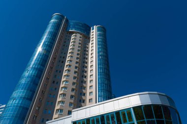 Mavi gökyüzüne karşı yüksek binalar.