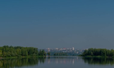 Gölün karşısından uzak şehir manzarası.