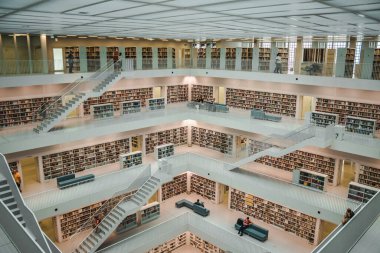 Stuttgart, Almanya - Almanya 'da Stuttgart Kütüphanesi (Stadtbiliothek Stuttgart) Ekim 2011' de açıldı ve Yi Mimarlar tarafından tasarlandı. Beyaz bir kütüphanenin minimalist bir iç mekanı. Dünyanın her yerinde çeşitli kitap ve ziyaretçiler var.