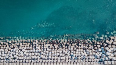 İspanya 'nın Malaga limanındaki dalgalardan kıyıları koruyan beton blokların hava görüntüsü.