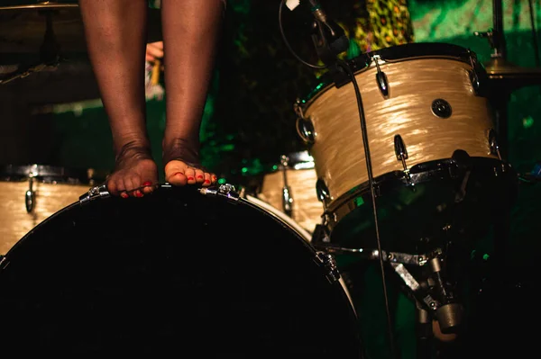 Girl\'s feet on top of a drum sets in stage