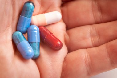 El ele tutuşup beş tane renkli hap yaklaş.