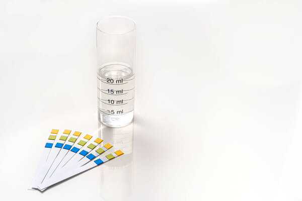 Тестовые полоски с тестовой трубкой, оконченные водой с копировальным пространством справа на белом фоне