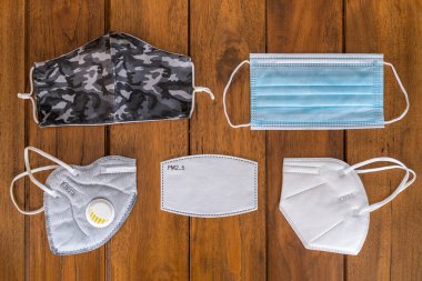 COVID-19, FPP2, KN95, FP2.5 filtresi, hijyenik maske, cerrahi maske ve tekstil yeniden kullanılabilir yüz maskesi, ahşap arka plan görünümlü