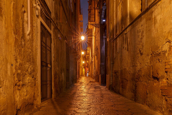 Old narrow medieval street in the light of lanterns. Palermo. Sicily. Italy.