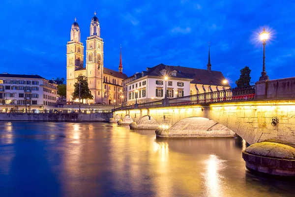 Zurich. Vista del terraplén de la ciudad y la iglesia Grossmunster al atardecer . — Foto de Stock