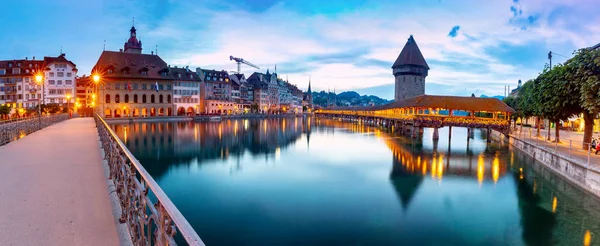 Lucerna. A famosa Capela, ponte Kapellbrucke ao amanhecer em iluminação noturna . — Fotografia de Stock