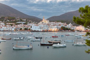 İspanya, Kadavra manzarası, gün batımında Santa Maria Kilisesi ve sakin Akdeniz körfezine demir atmış tekneler.