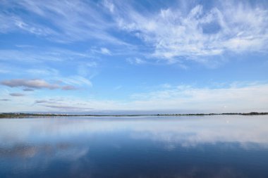 Mavi gökyüzünün altında pürüzsüz su yüzeyi
