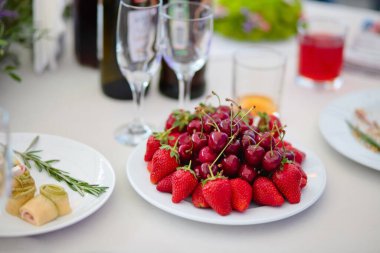 Bir tabakta kiraz ve çilek