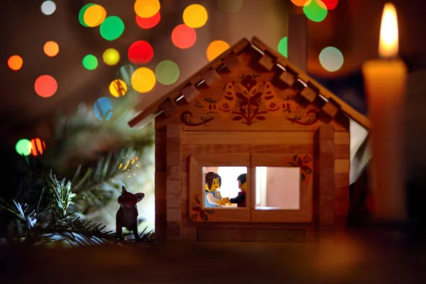 Christmas and New Year card: toy winter house at night with two lego people — Stock Photo, Image