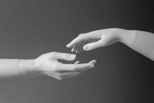 Дві руки манекенів тягнуться одна до одної. Поняття любові та допомоги — стокове фото