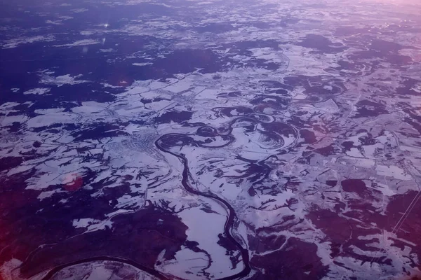 Λυκόφως άποψη σε χιονισμένο έδαφος από το αεροπλάνο το χειμώνα — Φωτογραφία Αρχείου