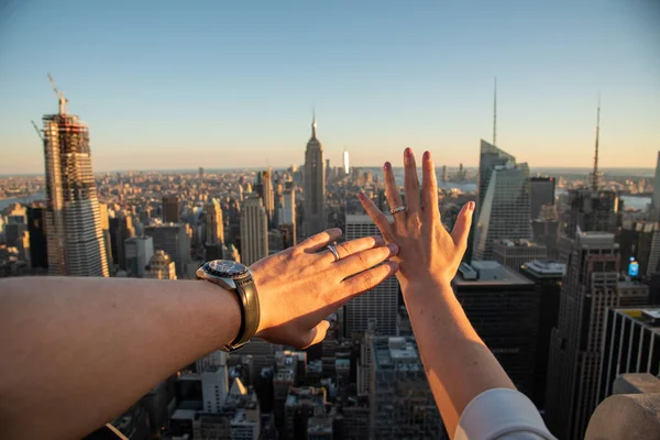 Mains avec des anneaux de désherbage avec l'Empire State en arrière-plan — Photo