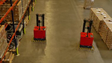 Kırmızı otomatik forkliftlerle endüstriyel üretim hattının görüntüleri