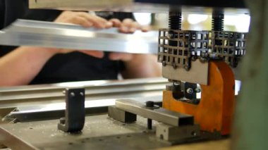 Metal profilinde delikler açan kişinin yakın çekim görüntüleri, endüstriyel üretim