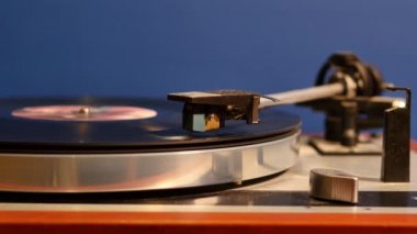 Mavi arkaplanda vinil kayıt oynatıcının yakın çekim görüntüleri