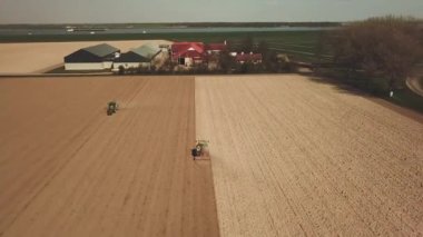 Traktör, Flevopolder Holland 'da, Aerial' da toprağı tozla kaplıyor.