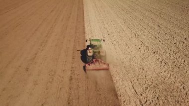 Traktör, Flevopolder Holland 'da, Aerial' da toprağı tozla kaplıyor.