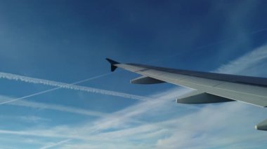 Uçak kanatları ve gökyüzünde beyaz çizgiler
