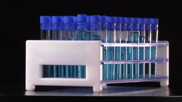 Probówki Niebieskim Płynem Obracającym Się Czarnym Tle Laboratorium — Wideo stockowe
