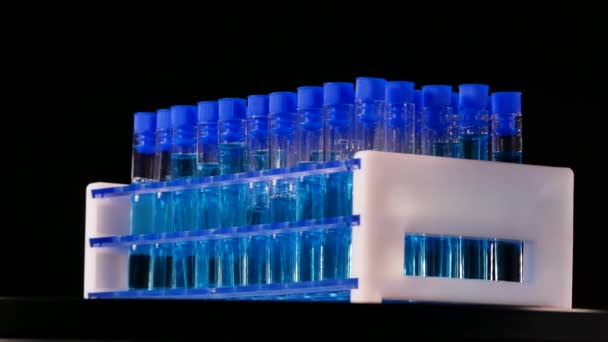 Tubos Ensayo Con Líquido Azul Girando Sobre Fondo Negro Laboratorio — Vídeo de stock