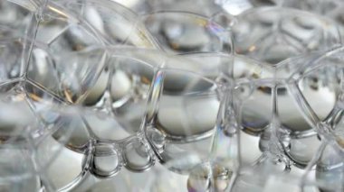 Gökkuşağı sabun köpükleri soyutlanmış arka planda parlıyor.