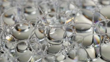 Gökkuşağı sabun köpükleri soyutlanmış arka planda parlıyor.