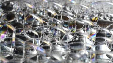 Gökkuşağı sabun köpükleri soyutlanmış arka planda parlıyor.