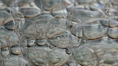 Gökkuşağı sabun köpükleri soyutlanmış arka planda parlıyor.