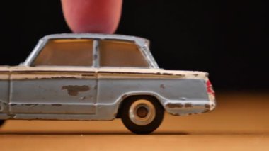 Ahşap masada siyah arka planı olan eski metal oyuncak araba.