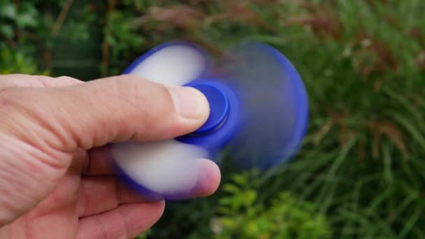 Main tenant populaire violon spinner jouet sur fond de ciel