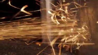 Metal öğütücü siyah arkaplanda parlak kıvılcımlar oluşturuyor