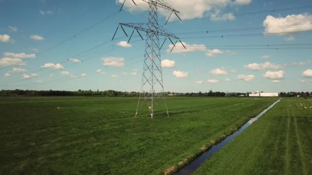 緑の電場を持つ高電圧パイロン青い空と積雲の電柱4Kで撮影された空中 — ストック動画
