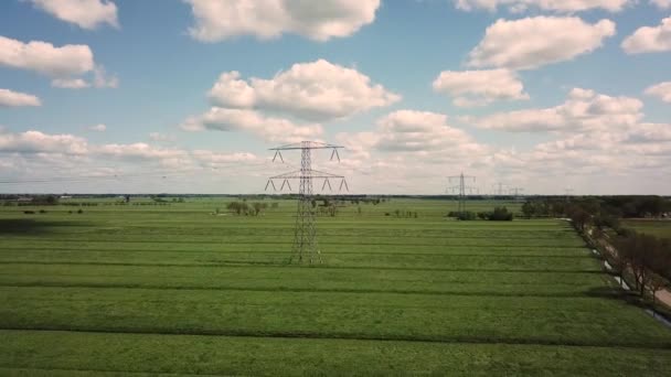 緑の電場を持つ高電圧パイロン青い空と積雲の電柱4Kで撮影された空中 — ストック動画