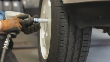 Garajda bir arabanın tekerleğini sökmek. Yakın çekim.