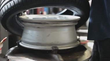 Garajda lastik tamir eden bir makine var. Makineye yeni bir lastik takılmış.