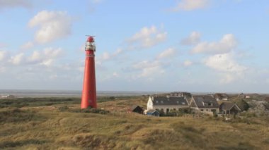 Gökyüzünde güzel bulutlar olan Schiermonnikoog adasındaki deniz feneri. Geniş açılı çekim.