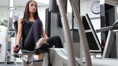 Güzel esmer bir kadının spor salonunda spor yaparken çekilmiş görüntüleri.