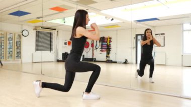 Güzel esmer bir kadının spor salonunda spor yaparken çekilmiş görüntüleri.